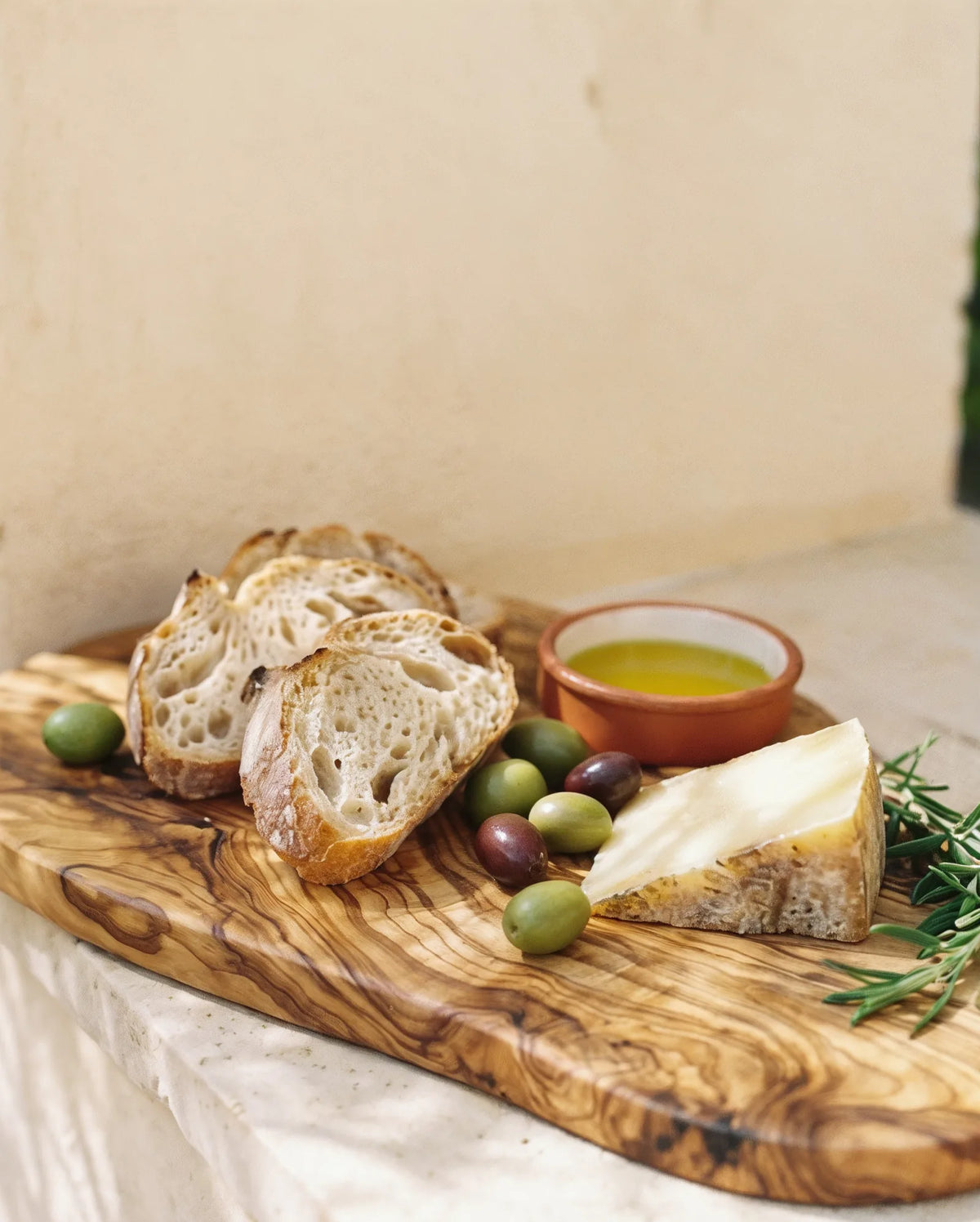 Olivenholzbrett als Kaese- und Apero-Brett mit Brot, Kaese und Oliven